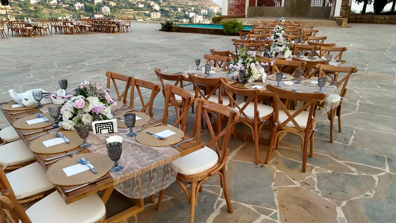 Dinner tables with wooden chairs on the stone courtyard