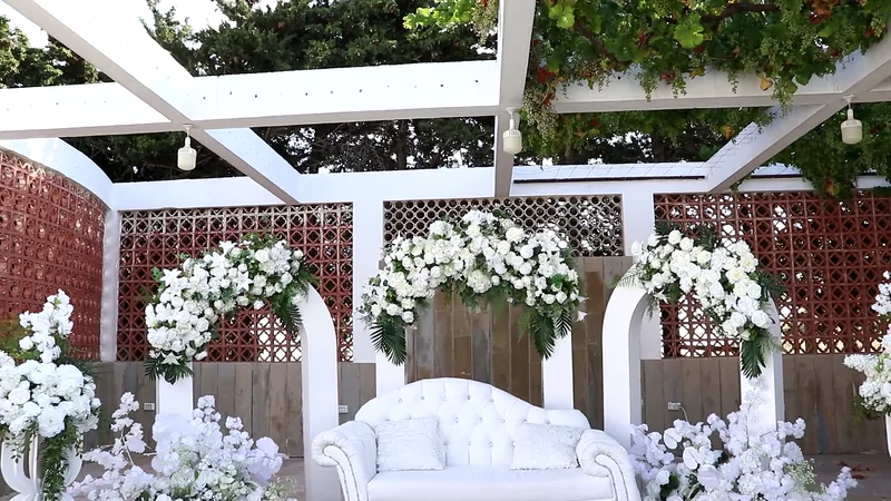 The white pergola stage dressed with white flowers